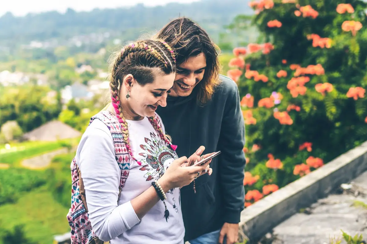 Two people happily reviewing options together on a phone